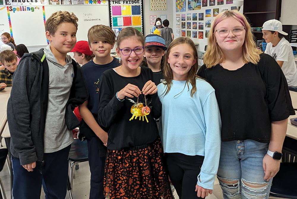 Fifth-graders in Stephanie Ising’s class at Mars Area Centennial School show off their model of a firefly, created as part of science project led by Mars Area High School students. 